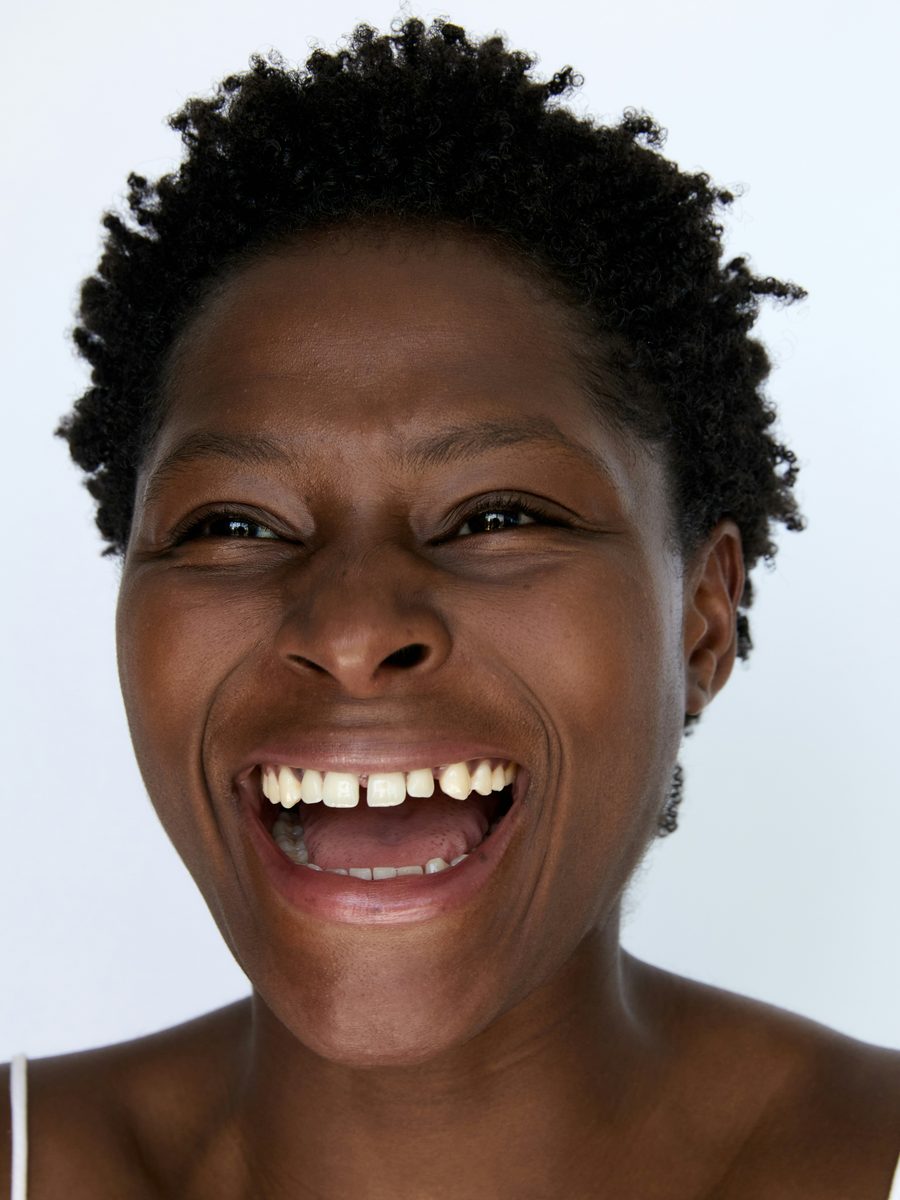 A patient smiling openly after cosmetic treatment at Glaze